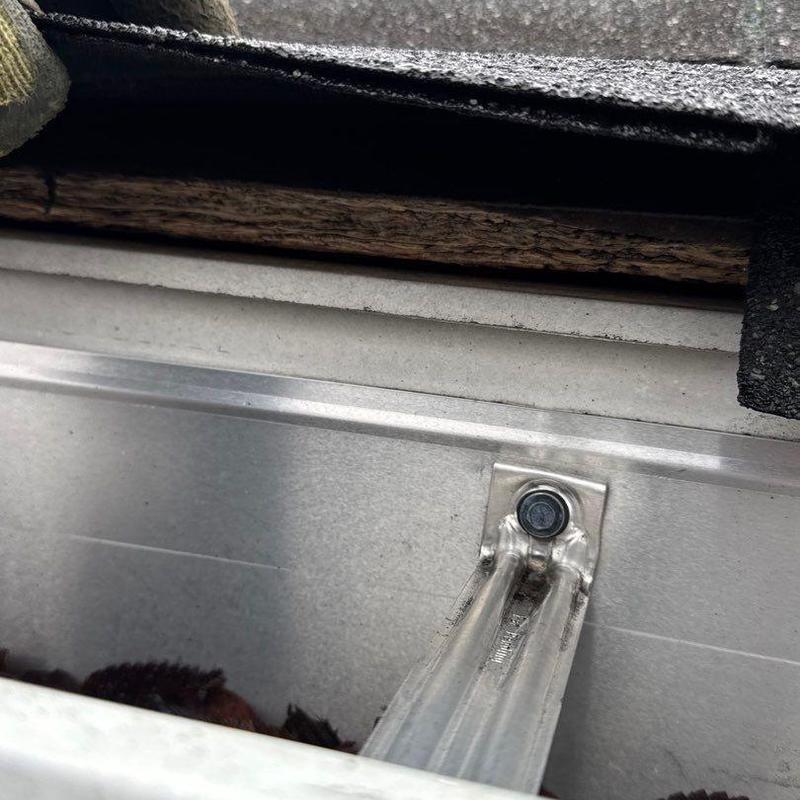 Roof flashing close-up showing hail damage to shingles