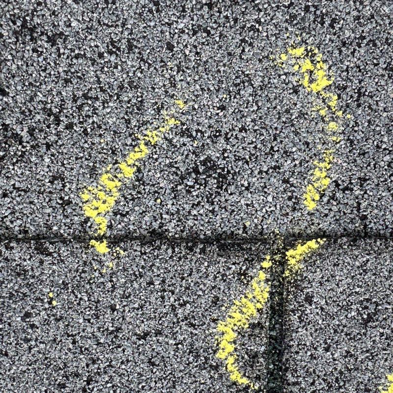 Roof shingles with yellow markings indicating hail damage