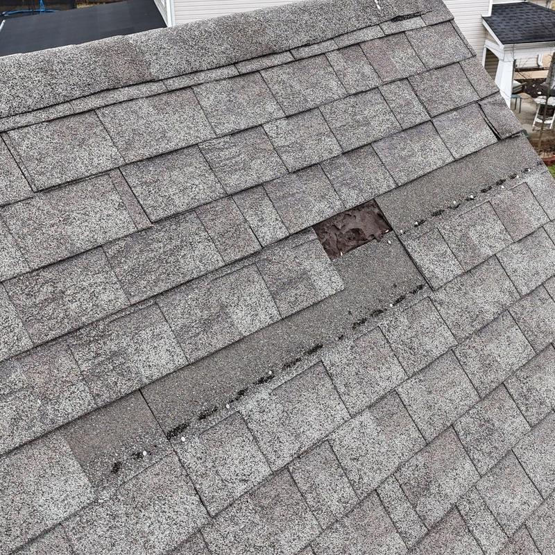 Asphalt roofing shingles with hail damage and missing shingle