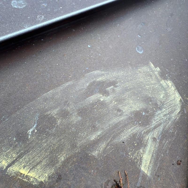 Metal roof panel with hail damage and chalk markings