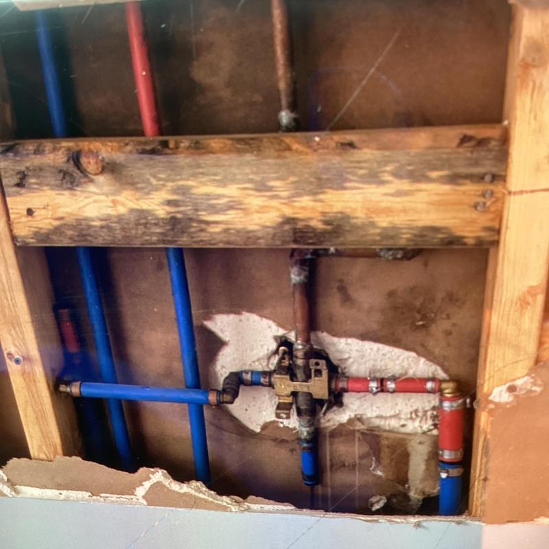 Copper and PEX plumbing pipes with valve exposed in wall cavity Copper and PEX plumbing pipes with valve exposed in wall cavity