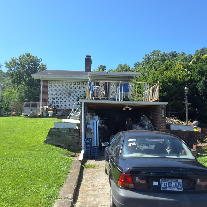 Asphalt shingle roof with aging and wind damage on home Asphalt shingle roof with aging and wind damage on home