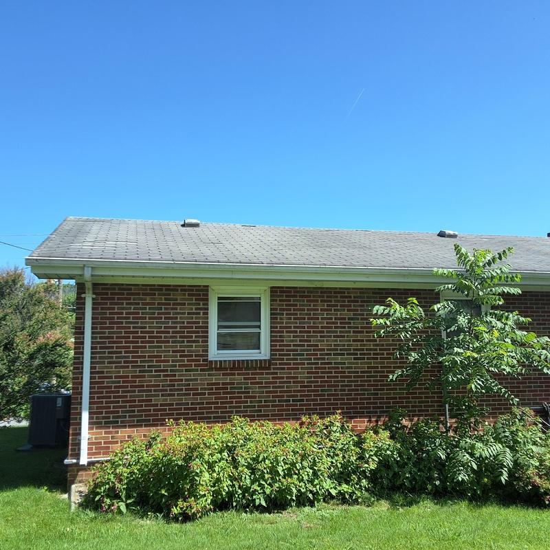 Asphalt shingle roof with visible age and wind damage Asphalt shingle roof with visible age and wind damage