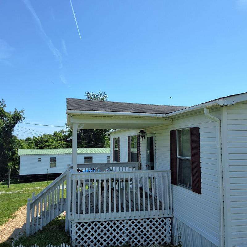 Asphalt shingle roof with porch and railing in daylight Asphalt shingle roof with porch and railing in daylight