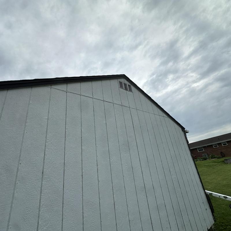 Outbuilding roof edge and siding under cloudy sky Outbuilding roof edge and siding under cloudy sky