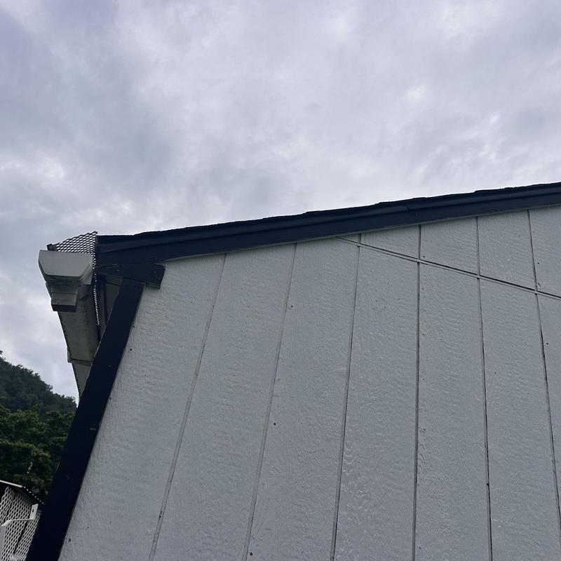 Outbuilding roof edge with new shingles and gutter guard Outbuilding roof edge with new shingles and gutter guard