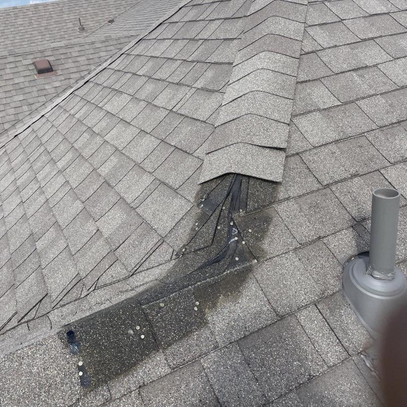 Asphalt shingle roof valley with storm damage and repair needed
