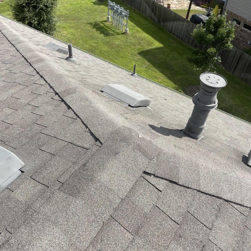 Asphalt shingle roof with vent pipe and ridge cap