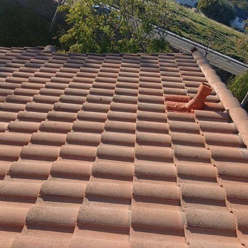 Tile roof with ventilation pipe and ridge cap installed Tile roof with ventilation pipe and ridge cap installed