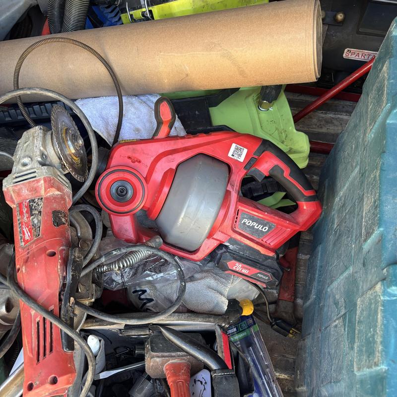 Drain cleaning machine and plumber tools in truck bed