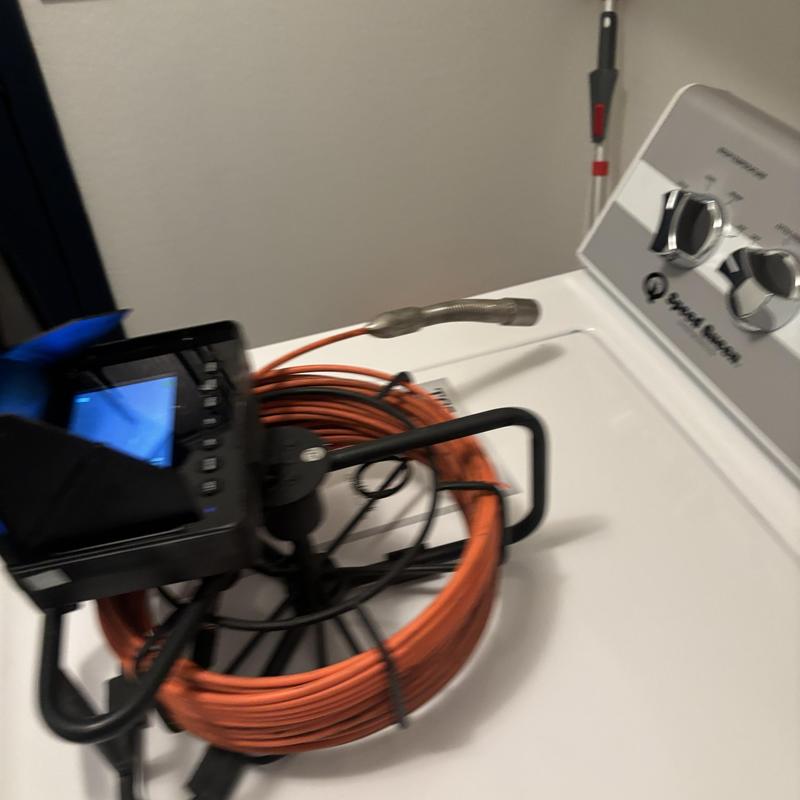 Drain line inspection camera with coiled cable on washer