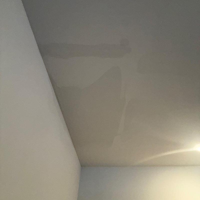 Drywall ceiling with water damage stain near light