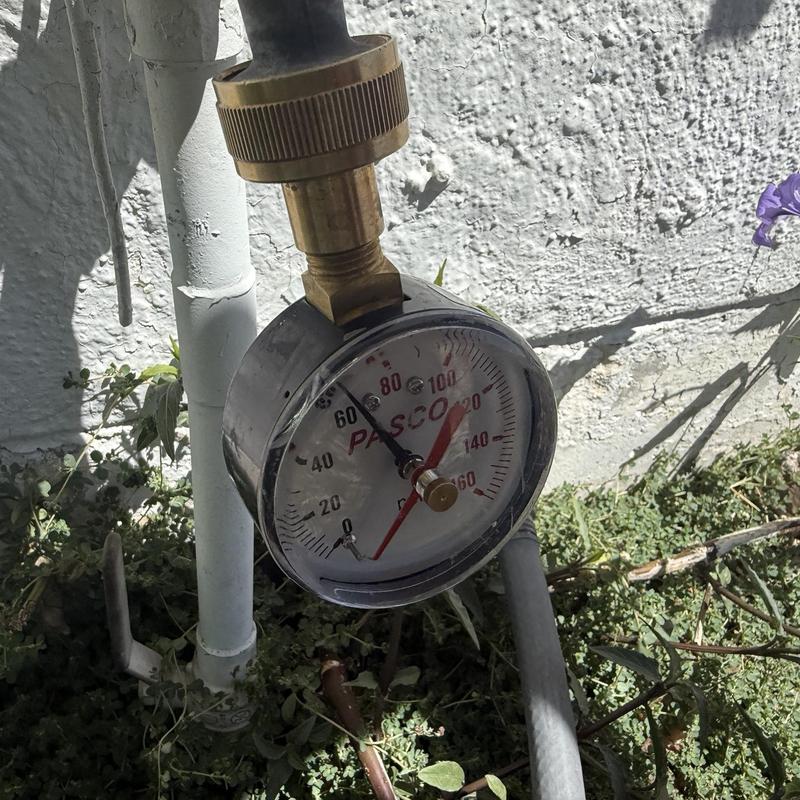 Water pressure gauge on outdoor plumbing system