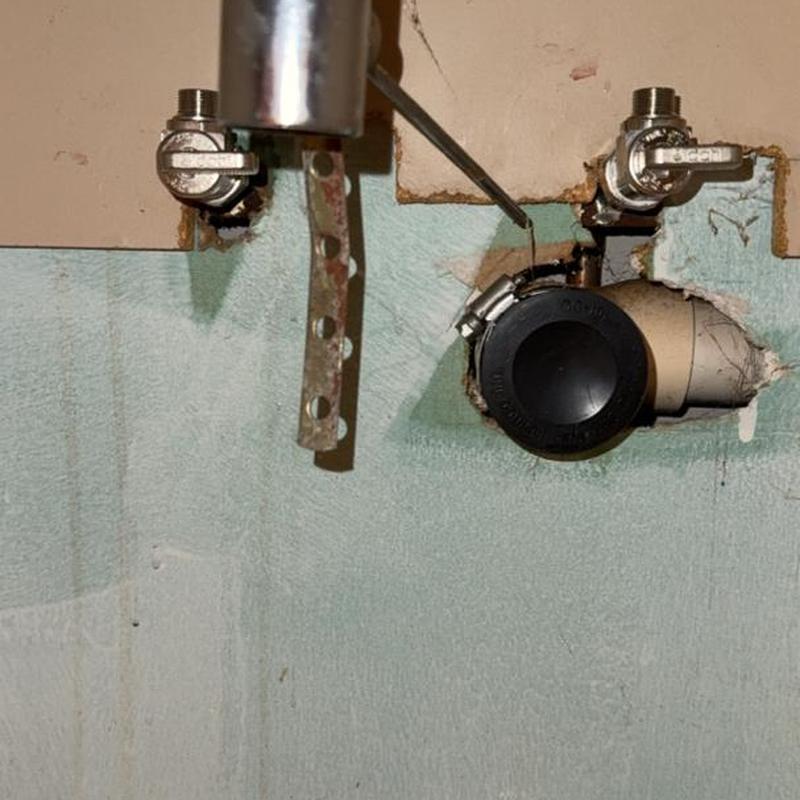 Water supply valves and capped pipe in wall opening Water supply valves and capped pipe in wall opening