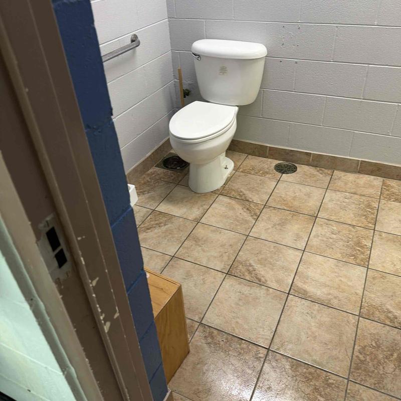 Toilet and mainline plumbing in tiled bathroom corner Toilet and mainline plumbing in tiled bathroom corner