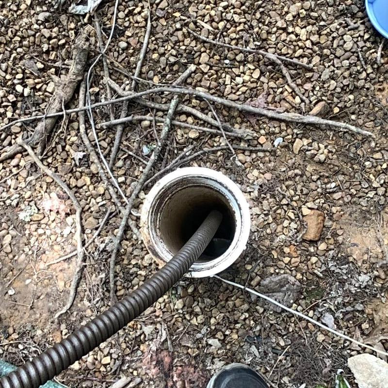 Main sewer line clearing with drain snake on gravel Main sewer line clearing with drain snake on gravel