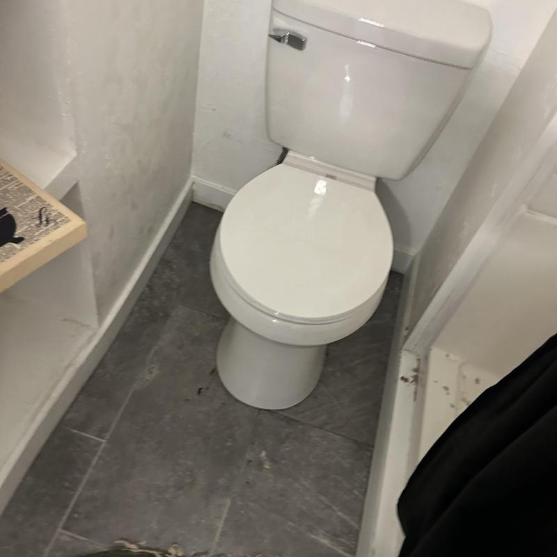 Toilet installation in basement bathroom corner