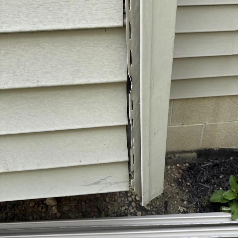 Vinyl siding panel with corner trim gap and damage Vinyl siding panel with corner trim gap and damage