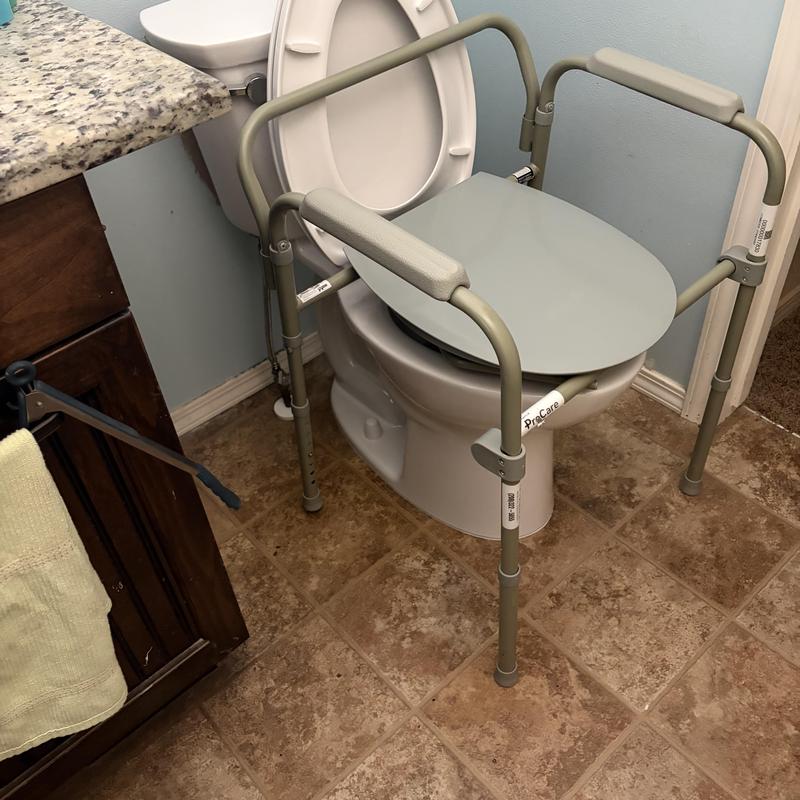 Toilet with safety frame and raised seat installation Toilet with safety frame and raised seat installation