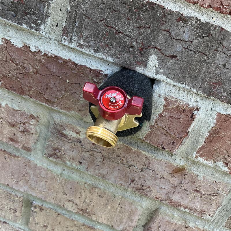 Outdoor quarter turn faucet with insulation on brick wall Outdoor quarter turn faucet with insulation on brick wall