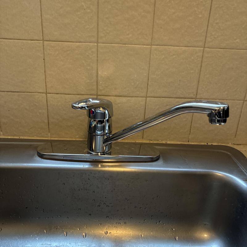 Kitchen faucet with single-handle lever on stainless sink