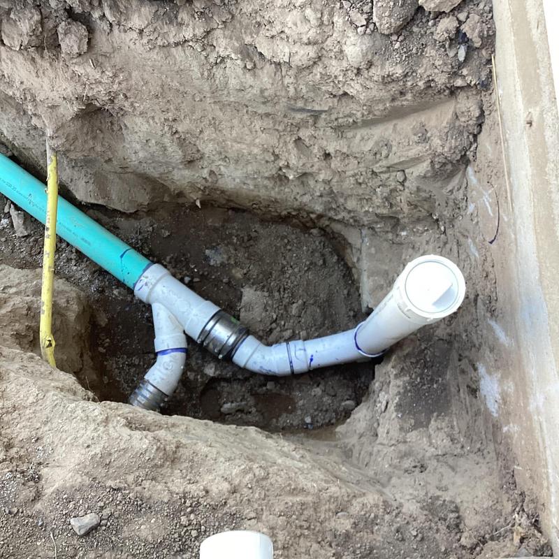 PVC sewer line excavation with new pipe fitting in ground PVC sewer line excavation with new pipe fitting in ground