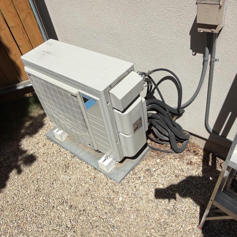 Mini-split outdoor condenser unit installed on pad Mini-split outdoor condenser unit installed on pad