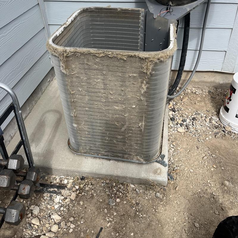 Condenser coil clogged with debris on HVAC unit outdoors