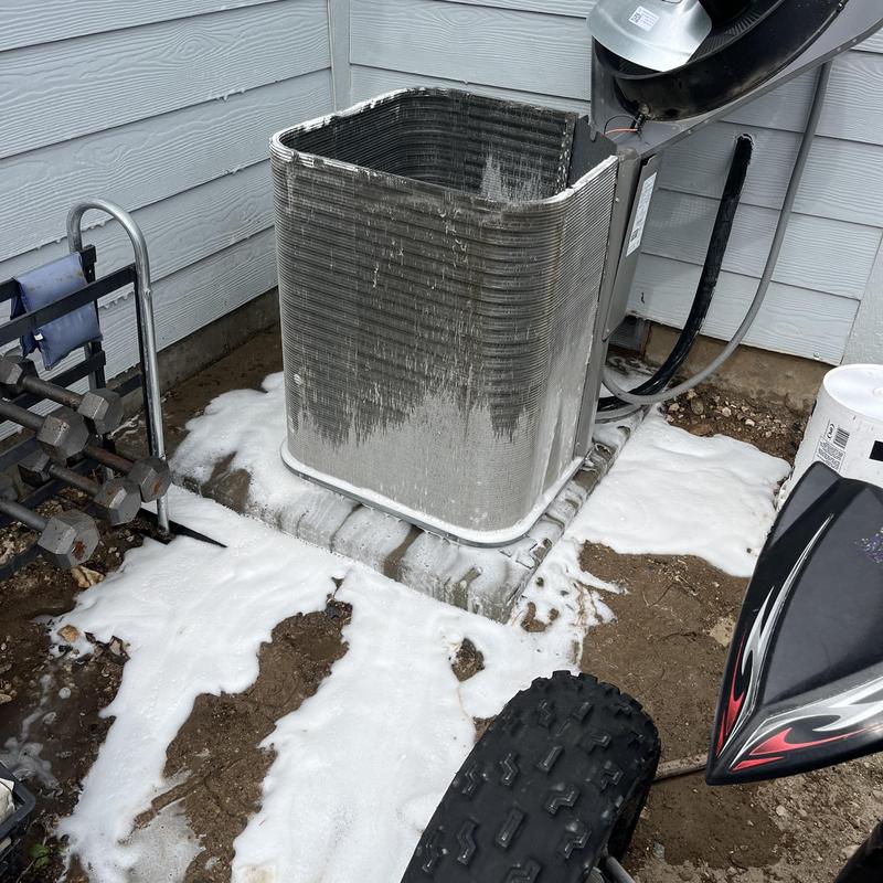 Condenser coil covered in cleaning foam outdoors