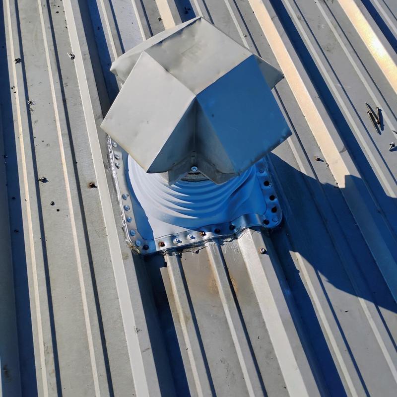 Metal roof vent with hail damage on corrugated roof