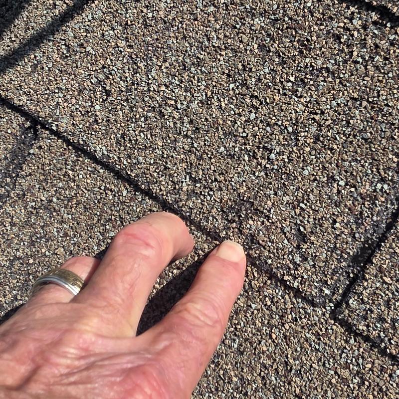 Asphalt shingle roof with hail damage close-up