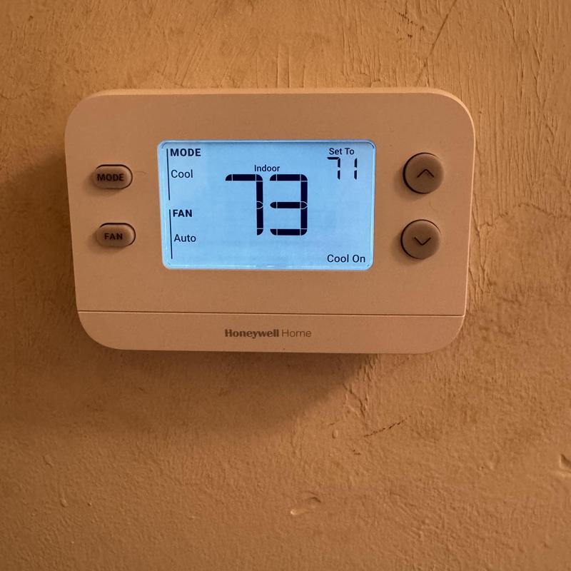 Honeywell thermostat displaying indoor temperature and settings