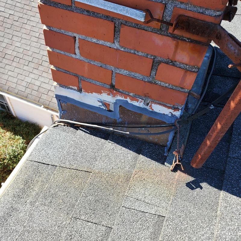Copper chimney flashing with gray asphalt shingles