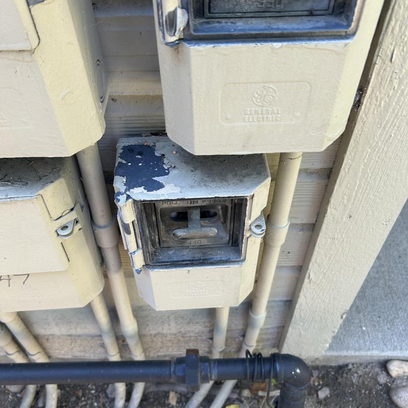 Air conditioning disconnect box with open cover outdoors Air conditioning disconnect box with open cover outdoors