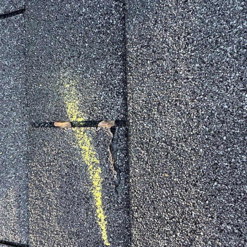 Asphalt shingle with hail damage and marked crack