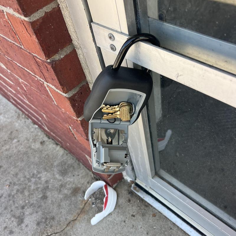 Key lock box with keys on metal door frame