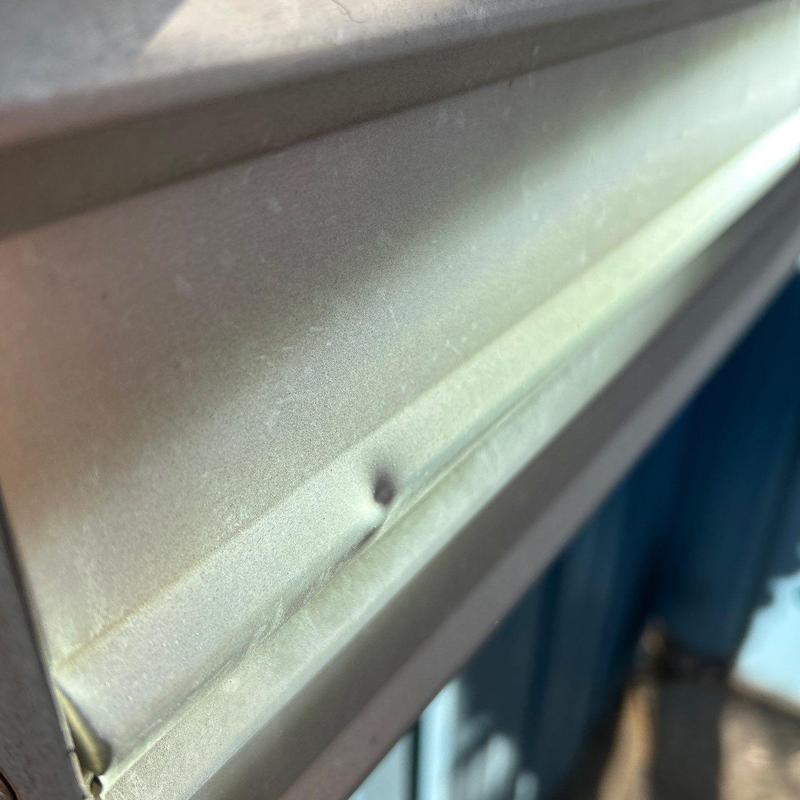 Metal roof panel dent with hail damage close-up