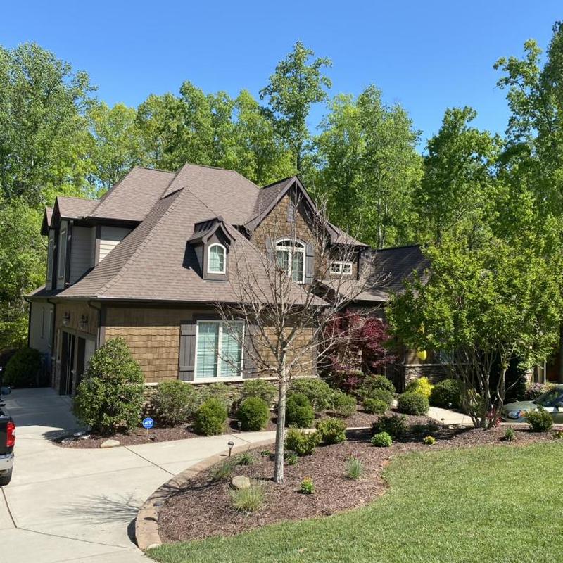 Roof shingles and gutters on a forested residential home