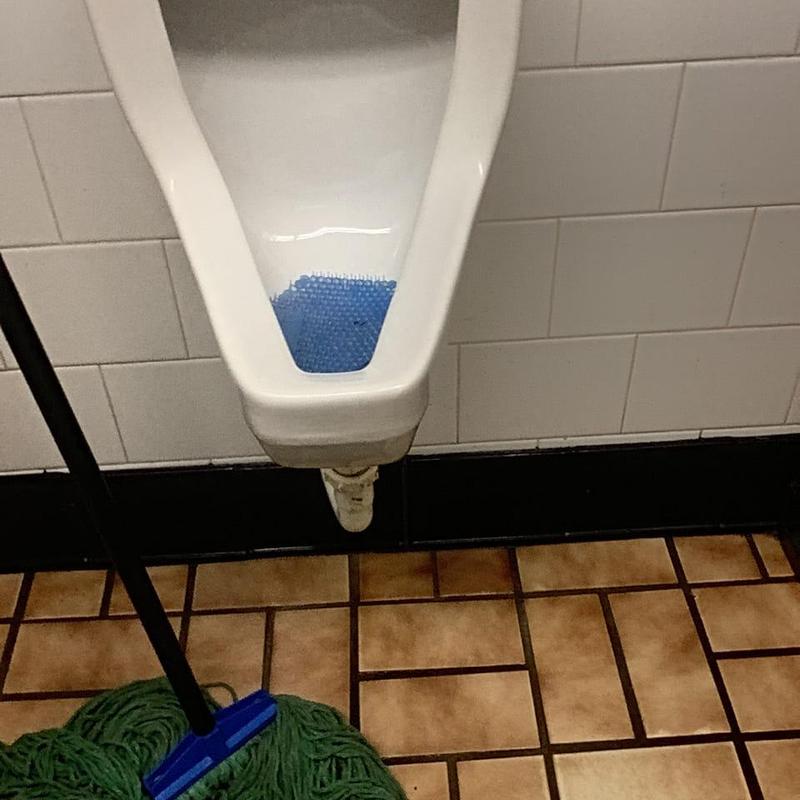 Urinal drain line with cleaning mop nearby Urinal drain line with cleaning mop nearby