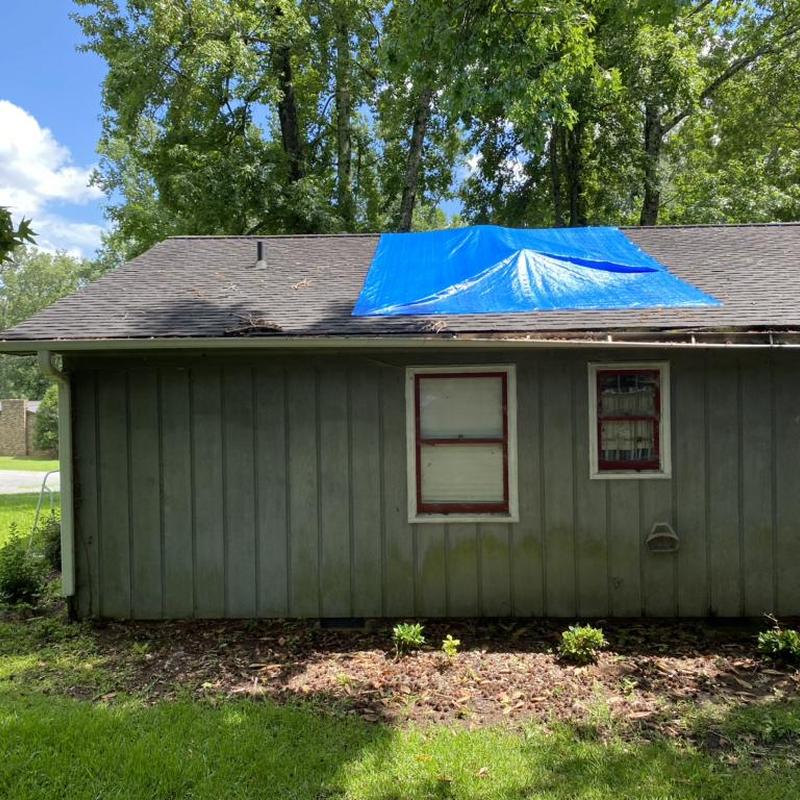 Roof with blue tarp covering storm damage area