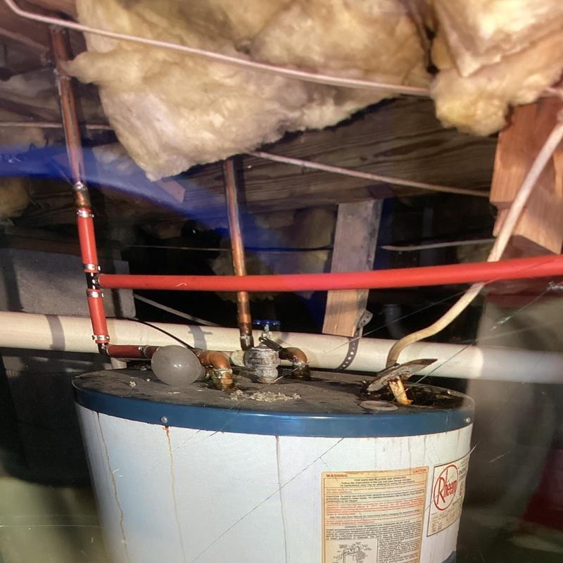 Electric water heater with plumbing connections in crawl space Electric water heater with plumbing connections in crawl space