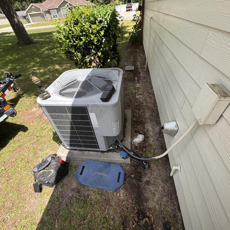 Heat pump outdoor unit with tools on ground