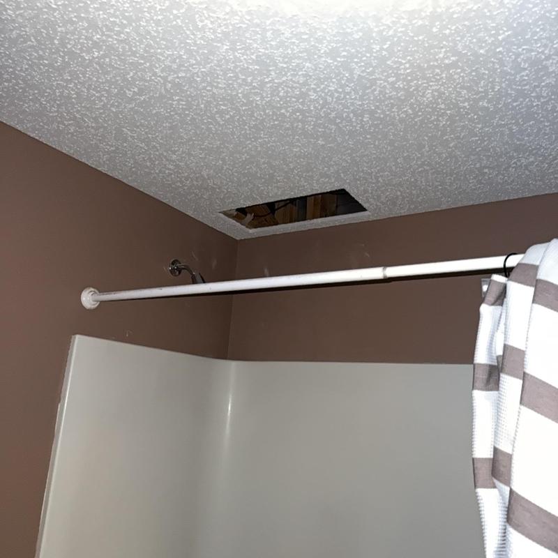 Bathroom ceiling with hole near shower curtain rod