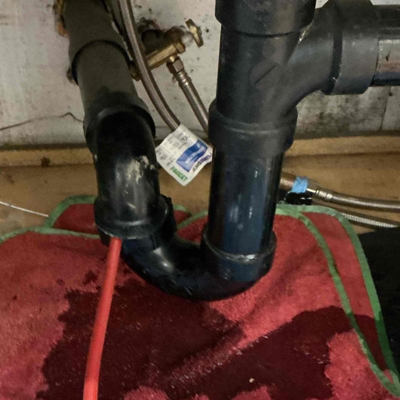 Drain line with rigid snake clearing debris