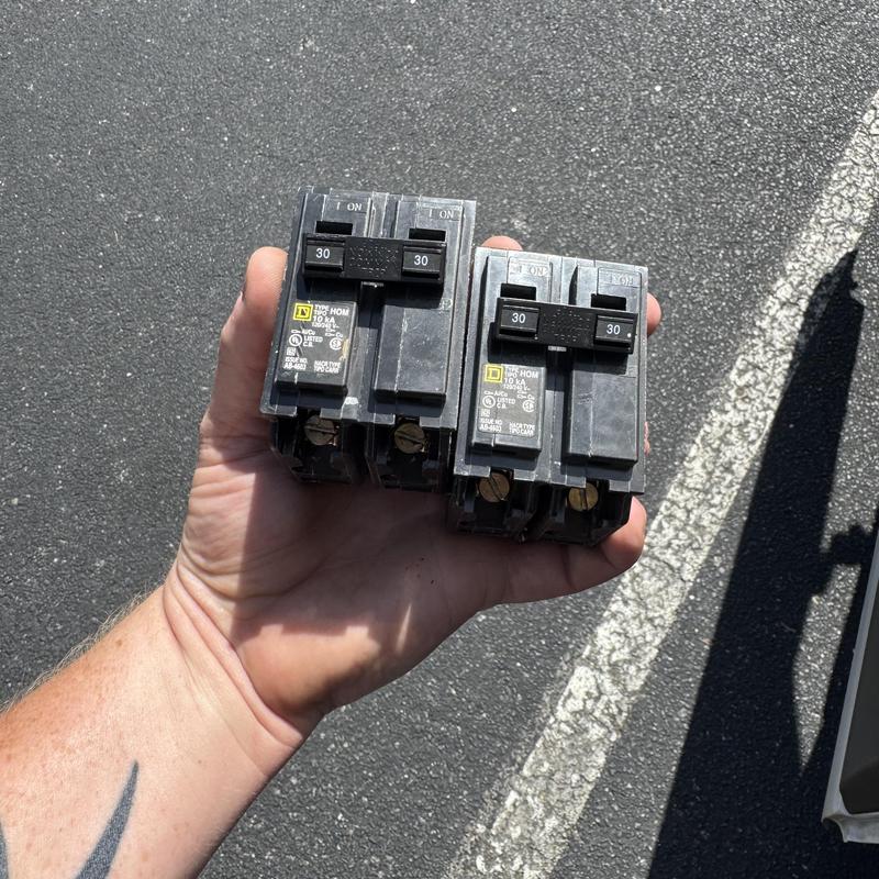 30-amp circuit breakers held in hand outdoors