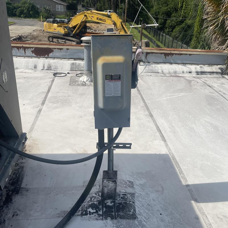 Electrical disconnect box on rooftop with construction equipment