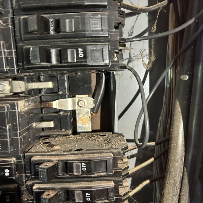Main service panel with arc damage and wiring hazards Main service panel with arc damage and wiring hazards