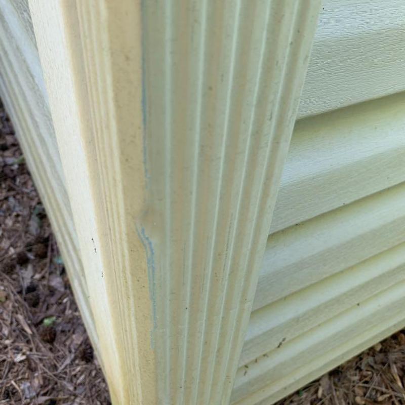 Vinyl siding corner trim close-up with weathering marks