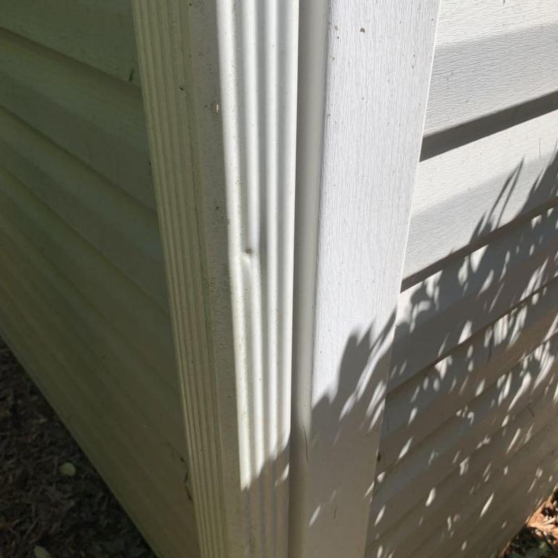 Vinyl siding corner trim with minor damage and dirt
