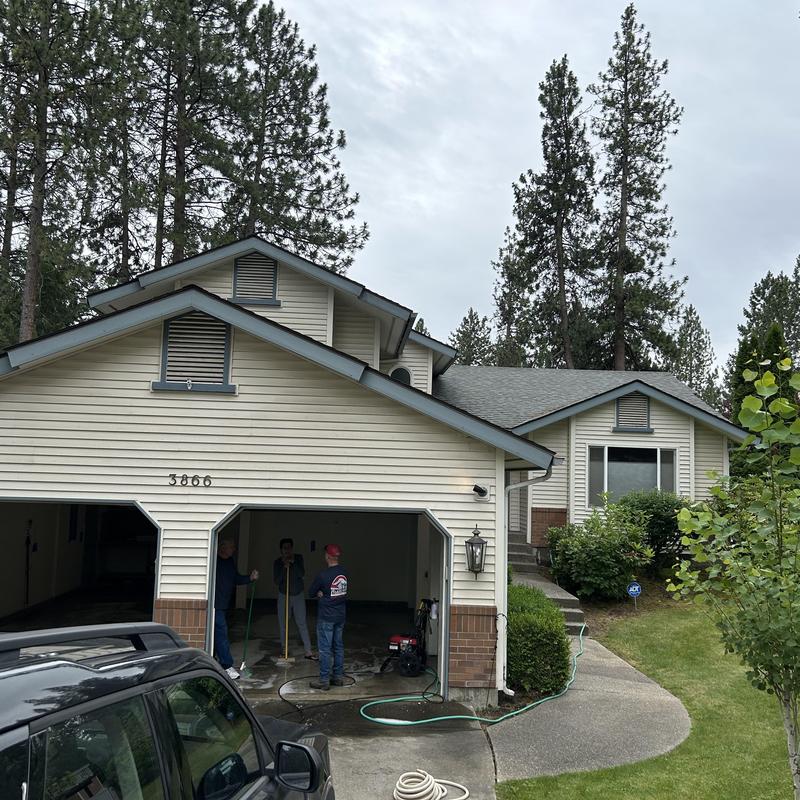 Asphalt shingle roof on house with repair crew nearby Asphalt shingle roof on house with repair crew nearby